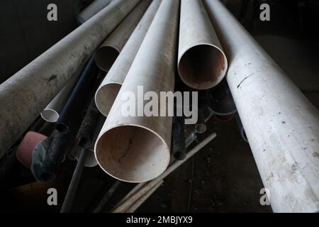 Primo piano dei tubi di cloruro di polivinile non plastificato (UPVC) utilizzati per i servizi idraulici che si posano l'uno sopra l'altro in un ambiente di costruzione Foto Stock