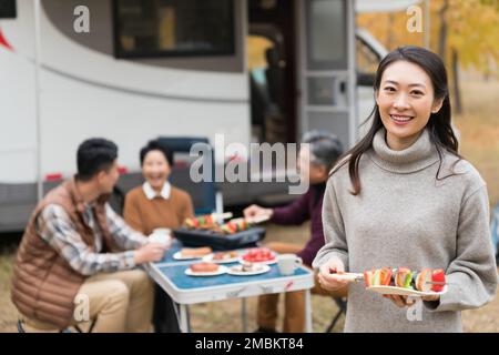 La famiglia felice di quattro barbecue autunnali all'aperto Foto Stock