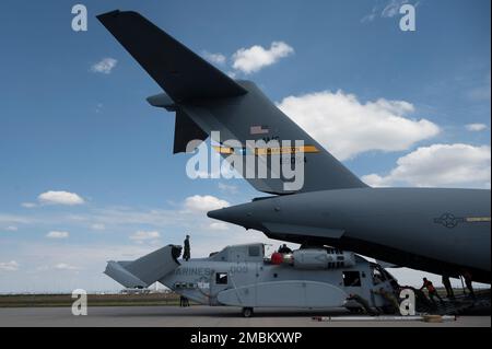 STATI UNITI L'equipaggio dell'aeronautica militare del 16th Airlift Squadron e degli Stati Uniti Marines da Marine Test and Evaluation Squadron-1, ascensore e scaricare un CH-53K King Stallion Helicopter da un US Air Force C-17 Globemaster III a Berlino, Germania, 15 giugno 2022. Il C-17 è il velivolo da carico più flessibile della forza di sollevamento aereo, in grado di sollevare rapidamente l'aereo strategico di truppe e carichi. Foto Stock