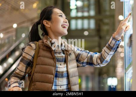 Le giovani donne usano una macchina self-service per acquistare bevande Foto Stock