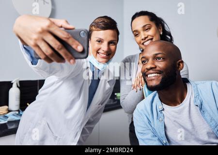 Fate del vostro sorriso la stella dello spettacolo. una giovane donna che prende selfie con la paziente dopo la sua procedura dentale. Foto Stock