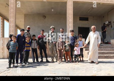 STATI UNITI I soldati assegnati ad attaccare la Compagnia 1/32 Fanteria, 1st Brigata, 10th Divisione montagna si impegnano con la popolazione locale in Siria il mese di giugno. 21, 2022. Combined Joint Task Force - l'operazione inerente Resolve continua a consigliare, assistere e consentire alle forze partner nelle aree designate della Siria di stabilire le condizioni per la sicurezza a lungo termine. Foto Stock