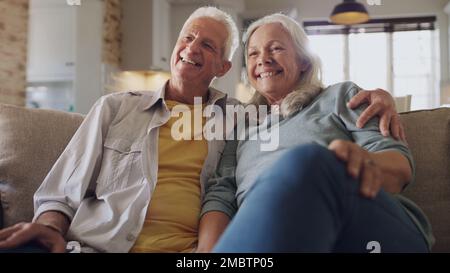 Questo era il nostro piano pensionistico. una coppia anziana felice seduta sul divano a casa e guardando la tv insieme. Foto Stock