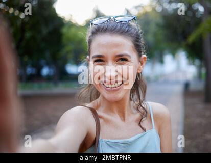 Selfie, giovane donna e casual nel parco, camminando e sorridere per divertimento, equilibrio e felicità. Ritratto, donna e donna con gioia, estate e agghiacciante Foto Stock