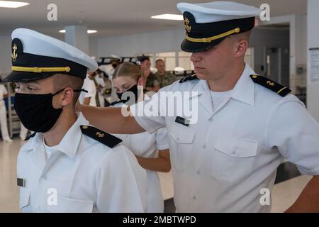 220622-N-ZW825-0739 GRANDI LAGHI, ILL. (22 giugno 2022) Un membro dello staff del corpo di addestramento degli ufficiali della Riserva Navale (NROTC) New Student Indottrination (NSI) conduce un'ispezione di uniforme bianca estiva del candidato dell'ostetrica al comando di addestramento del reclutamento (RTC), giugno 22. Al termine dell'NSI, i candidati inizieranno il loro anno nuovo del programma NROTC presso le università e le università nazionali questo autunno. NSI è un programma di indottrinamento ospitato presso RTC, e fornisce agli ostetrica un orientamento di addestramento militare comune. NSI fornisce una formazione di base in cinque principi fondamentali della lotta contro la guerra: Antincendio, danni c Foto Stock