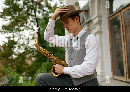 Ritratto di un giovane musicista con strumento musicale sassofono Foto Stock