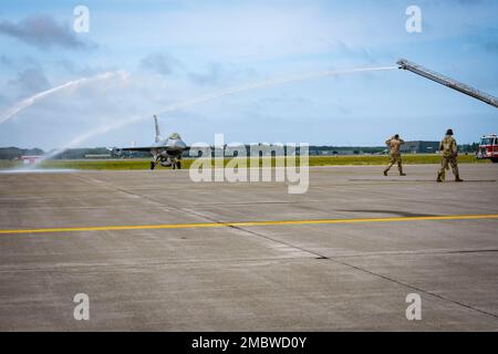 STATI UNITI Air Force 35th Civil Engineer Squadron Fire Emergency Services members Hose Down il col. Jesse J. Friedel, 35th Comandante dell'Ala combattente, mentre Taxi un F-16 Fighting Falcon durante il suo volo fini alla base aerea di Misawa, Giappone, 22 giugno 2022. Un volo finale, o fini-Flight, è una tradizione USAF, per celebrare l’ultimo volo con la propria unità, spruzzando champagne, facendo un brindisi e facendo un dowsing d’acqua da un camion dei pompieri sull’aereo e sull’equipaggio. Foto Stock