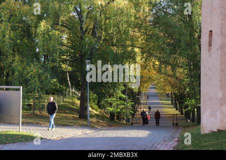 Un gruppo di persone che camminano da un castello di Uppsala, Svezia Foto Stock