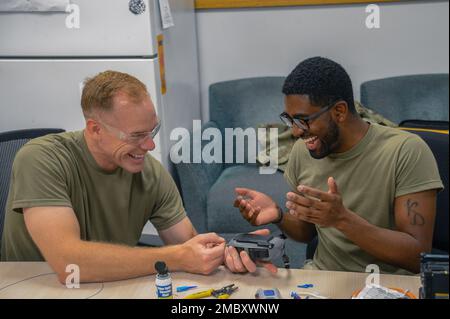 STATI UNITI Benjamin Jonsson, a sinistra, 6th Air Refuging Wing Commander, e gli Stati Uniti Air Force Senior Airman Davonte Love, un tecnico di cavi assegnato al 6th Communication Squadron (CS) giunto un cavo in rame alla base dell'aeronautica militare MacDill, Florida, 23 giugno 2022. Jonsson ha visitato il CS 6th per collegarsi con gli airmen e guadagnare una prospettiva migliore della loro vita quotidiana. Foto Stock