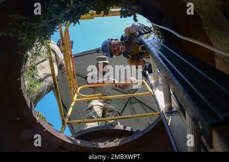 STATI UNITI Air Force Senior Airmen Haneef Muhammad e Davonte Love, tecnici di cavi assegnati al 6th Communication Squadron (CS) tenere una scala sopra un tombino durante una dimostrazione di unità presso la base dell'aeronautica militare di MacDill, Florida, 23 giugno 2022. La demo ha mostrato i compiti quotidiani eseguiti dal 6th CS, che include la manutenzione dell'infrastruttura elettrica che alimenta e fornisce servizi Internet alla base. Foto Stock