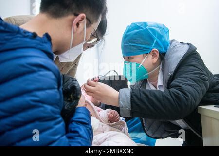 Wuhan, Provincia cinese di Hubei. 21st Jan, 2023. Un medico esamina un bambino presso la clinica di emergenza del Wuhan Children's Hospital di Wuhan, provincia di Hubei, Cina centrale, 21 gennaio 2023. Le persone di vari settori si attaccano ai loro posti alla vigilia del Capodanno cinese lunare, o Spring Festival, che cade il 22 gennaio di quest'anno. Credit: WU Zhizun/Xinhua/Alamy Live News Foto Stock