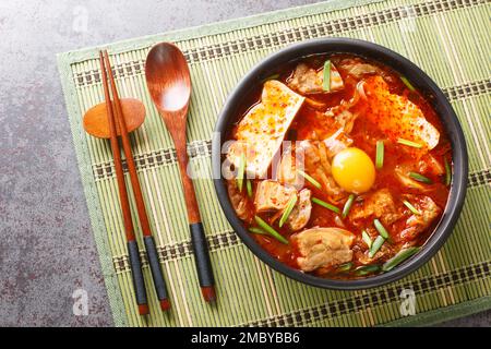 Sundubu jigae o stufato di tofu morbido, è un piatto tradizionale coreano fatto con tofu morbido e setoso rivestito in un primo piano speziato e saporito brodo Foto Stock