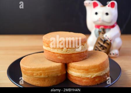 Stack di Imagawayaki o Obanyaki, tradizionale giapponese riempimento Pan torte con beckoning Cat Maneki-neko Foto Stock