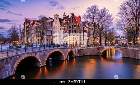 Amsterdam di notte con case colorate danzanti ai canali di Amsterdam nei Paesi Bassi. Foto Stock