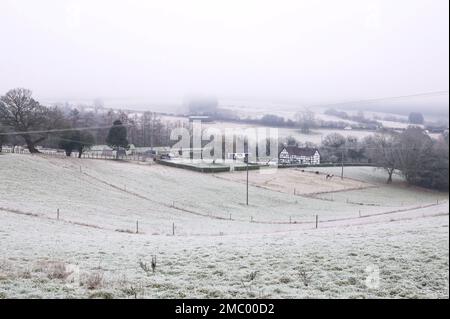 Drakelow, Worcestershire, 21 gennaio 2023 - Una casa di campagna in stile tudor situata in una valle vicino a Drakelow, Worcestershire, è circondata da campi ghiacciati e bassa nebbia gelida quando le temperature precipitarono ancora una volta durante la notte. Credito: Interrompi stampa Media/Alamy Live News Foto Stock