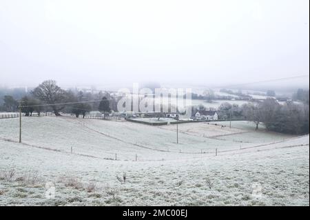 Drakelow, Worcestershire, 21 gennaio 2023 - Una casa di campagna in stile tudor situata in una valle vicino a Drakelow, Worcestershire, è circondata da campi ghiacciati e bassa nebbia gelida quando le temperature precipitarono ancora una volta durante la notte. Credito: Interrompi stampa Media/Alamy Live News Foto Stock