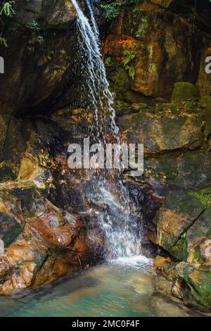 Piccola cascata, con piscina verde sotto nel parco di Isalo, Madagascar Foto Stock