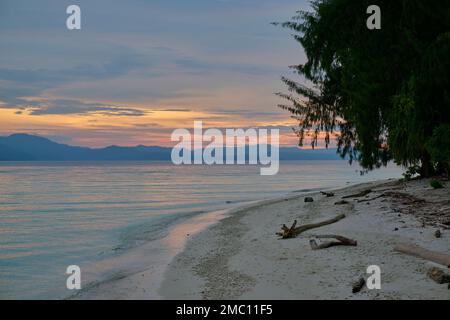 Il sole che scende sulle isole Raja Ampat, Indonesia Foto Stock