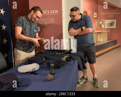 Ethan Dykes, un internista al museo navale di Hampton Roads, si impegna con i visitatori nella galleria della Guerra civile del museo su manufatti e oggetti associati alla USS Cumberland. Cumberland affondò durante un fidanzamento con il montone confederato, CSS Virginia il 8 marzo 1862. Il museo è il deposito ufficiale per i manufatti recuperati dal sito del relitto della USS Cumberland. Foto Stock