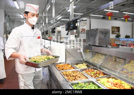 Pechino, Cina. 21st Jan, 2023. Un membro dello staff prepara i piatti per gli studenti in una mensa dell'Università Jiaotong di Pechino, capitale della Cina, 21 gennaio 2023. Le persone di vari settori si attaccano ai loro posti alla vigilia del Capodanno cinese lunare, o Spring Festival, che cade il 22 gennaio. Credit: Ren Chao/Xinhua/Alamy Live News Foto Stock