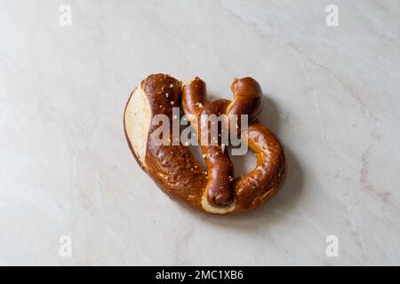 Morso il pretzel residuo sulla superficie di marmo. Cibo tradizionale. Foto Stock