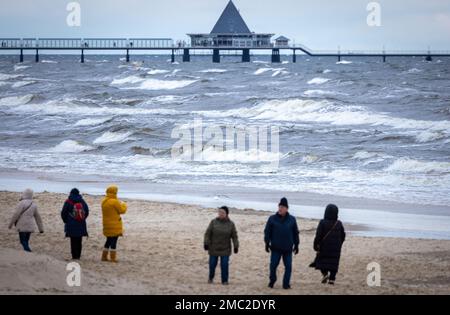 Ahlbeck, Germania. 21st Jan, 2023. Gli escursionisti sono fuori e in giro nel tempo tempestoso sulla costa baltica sull'isola di Usedom. Con venti forti e temperature intorno a zero gradi, il clima invernale nel nord della Germania mostra il suo lato tipico. Credit: Jens Büttner/dpa/Alamy Live News Foto Stock