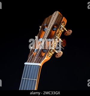 Dettaglio della testa della chitarra classica isolato su sfondo nero. Chitarra acustica classica. Perfetto per volantini, biglietti, poster o sfondi Foto Stock