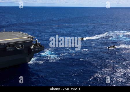 OCEANO PACIFICO (24 giugno 2022) i velisti della Royal Australian Navy in gommoni a scafo rigido (RHIBs) si avvicinano al cacciatorpediniere giapponese JS Izumo (DH-184) durante una visita in elicottero, un giro a bordo, una ricerca e un sequestro (HVBSS) in collaborazione con il gruppo Abraham Lincoln Carrier Strike Group (ABECSG). ABECSG sta conducendo operazioni di routine nella flotta degli Stati Uniti 3rd. Una parte integrante di U.S. Pacific Fleet, U.S. 3rd Fleet è alla guida delle forze navali nell'Indo-Pacifico e fornisce la formazione realistica e pertinente necessaria per svolgere in modo impeccabile il ruolo della nostra Marina Foto Stock