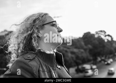 Vista laterale di una donna bionda e ricciola più-misura Foto Stock