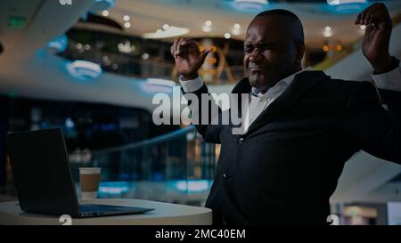 Uomo afroamericano adulto uomo d'affari di mezza età manager freelancer lavorare con il computer in ufficio società caffè navigazione digitando laptop sensazione indietro Foto Stock