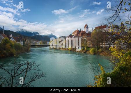 Fussen Skyline con il fiume Lech, St. Basilica di Mang e Alpi di Allgau - Fussen, Baviera, Germania Foto Stock