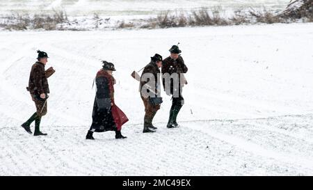 Gammelsdorf, Germania. 21st Jan, 2023. I cannonieri di Boeller camminano attraverso un campo coperto di neve. Diverse centinaia di partecipanti sono venuti alla riunione invernale del patriota dell'Associazione di Königstreuen in Baviera per commemorare la Battaglia di Gammelsdorf nel 1313, considerata l'ultima grande battaglia di cavalieri. Secondo le proprie informazioni, il Verband der Königstreuen e.V. serve a mantenere i costumi bavaresi, la lingua bavarese e la storia, nonché a ricercare il significato della Baviera al tempo dei re bavaresi. Credit: Stefan Puchner/dpa/Alamy Live News Foto Stock