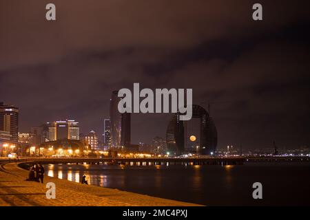 Baku. Azerbaigian. 01.29.2021 anno. La luna piena sorge sopra la città tra gli edifici. Foto Stock