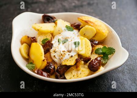 Pastinaca saltata con datteri e yogurt piccante di soia Foto Stock