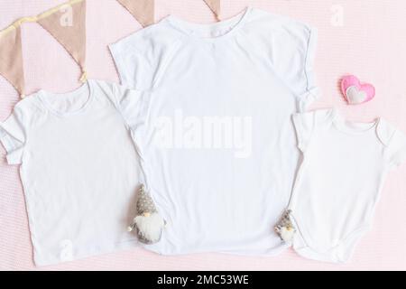 Il giorno di San Valentino mamma e bambini mockup t-shirt bianca e baby bodysuit onesie con gnomi e cuore su sfondo rosa Foto Stock