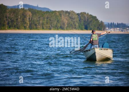 Un pescatore che cattura il pesce mentre usando una rete Foto Stock