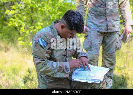 STATI UNITI Esercito 1st Lt. Juan Laguna, assegnato alla truppa Bravo, 4th Squadron, 10th Cavalleria Regiment, 3rd squadra di combattimento della Brigata Armorata, 4th Divisione di Fanteria, coordinate su una mappa durante una corsia per stabilire un punto di osservazione come parte di un giro di Spur a Drawsko Pomorskie, Polonia, 25 giugno 2022. Soldati di varie unità hanno partecipato al Spur Ride, un evento impegnativo in cui la forma fisica e il lavoro di squadra sono necessari per emergere e guadagnare i loro spur. Foto Stock