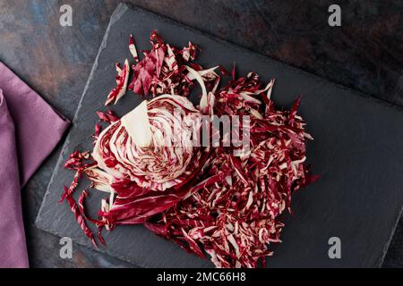 Insalata di radicchio grattugiata su fondo scuro. Radichio insalata su un tavolo di ardesia. Vista dall'alto Foto Stock