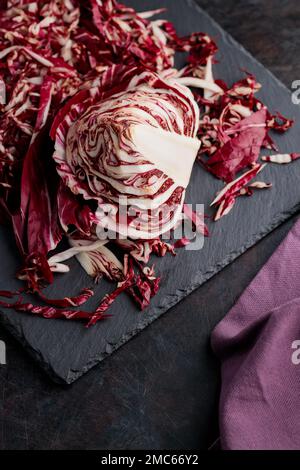 Insalata di radicchio grattugiata su fondo scuro. Radichio insalata su un tavolo di ardesia. Vista dall'alto Foto Stock