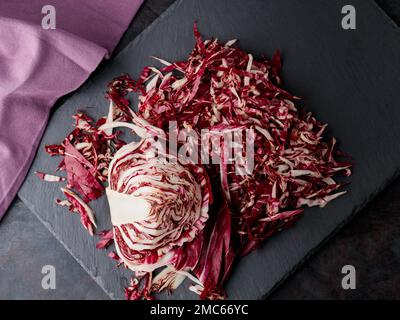 Insalata di radicchio grattugiata su fondo scuro. Radichio insalata su un tavolo di ardesia. Vista dall'alto Foto Stock