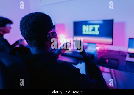I giovani gamer si divertono a giocare sulla piattaforma di gioco blockchain NFT decentralizzata con occhiali per realtà virtuale a casa Foto Stock