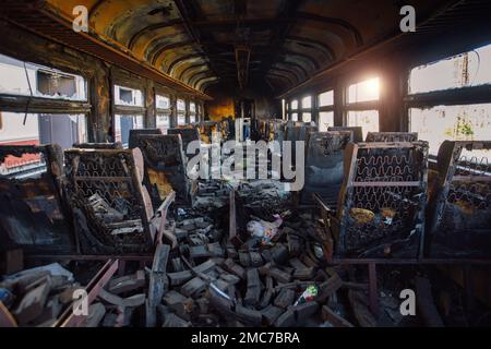 Allenati dopo il fuoco. Interno bruciato del trasporto passeggeri. Conseguenze del fuoco o della guerra. Foto Stock