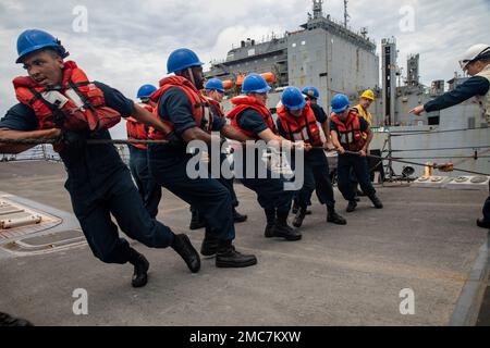 MARE DELLA CINA ORIENTALE (26 giugno 2022) i marinai a bordo del cacciatorpediniere missilistico guidato della classe Arleigh Burke USS Dewey (DDG 105) erigono una linea durante un rifornimento in mare con la nave da carico a secco della classe Lewis e Clark USNS Cesar Chavez (T-AKE-14). Dewey è assegnato al Comandante, Task Force 71/Destroyer Squadron (DESRON) 15, il più grande DESRON schierato in avanti della Marina e la principale forza di superficie della flotta degli Stati Uniti 7th. Foto Stock