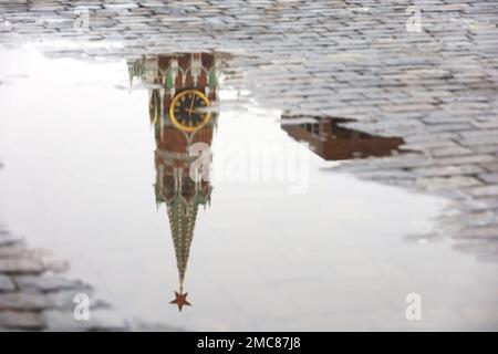 Mosca Piazza Rossa durante la pioggia. Riflesso della torre del Cremlino e delle persone che camminano in una pozza d'acqua, sciogliendo la neve Foto Stock