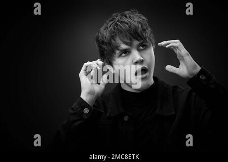 pazzo giovane uomo con capelli impressionante grimacing Foto Stock