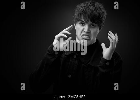 pazzo giovane uomo con capelli impressionante grimacing Foto Stock