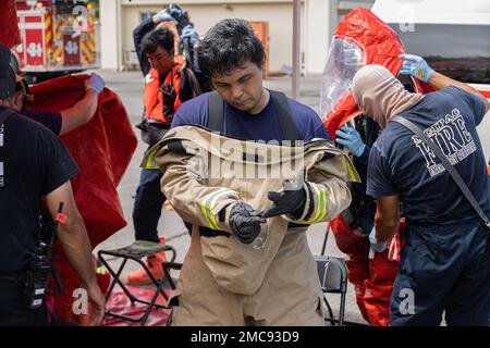 Un vigile del fuoco con installazioni del corpo Marino Pacific Fire and Emergency Services prepara i suoi attrezzi durante un esercizio di addestramento sui materiali pericolosi a Camp Hansen, Okinawa, Giappone, 27 giugno 2022. La formazione HAZMAT ha incluso più vittime simulate in un ambiente pericoloso, neutralizzando al contempo l'area contaminata. MCIPAC F&ES è un reparto antincendio regionale che gestisce otto stazioni antincendio in tutto il Giappone e fornisce servizi alle installazioni, tra cui antincendio, soccorso tecnico, materiali pericolosi, pronto soccorso, protezione antincendio e prevenzione. Foto Stock