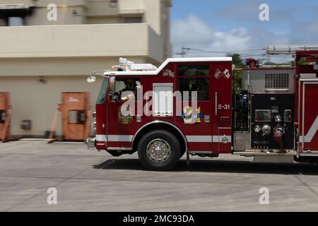 Vigili del fuoco con installazioni di corpi marini i servizi antincendio e di emergenza del Pacifico arrivano a un'emergenza simulata durante un esercizio di addestramento sui materiali pericolosi a Camp Hansen, Okinawa, Giappone, 27 giugno 2022. La formazione HAZMAT ha incluso più vittime simulate in un ambiente pericoloso, neutralizzando al contempo l'area contaminata. MCIPAC F&ES è un reparto antincendio regionale che gestisce otto stazioni antincendio in tutto il Giappone e fornisce servizi alle installazioni, tra cui antincendio, soccorso tecnico, materiali pericolosi, pronto soccorso, protezione antincendio e prevenzione. Foto Stock