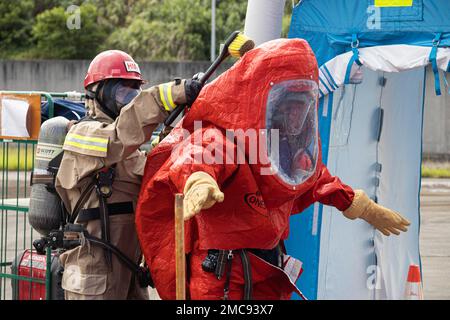 Vigili del fuoco con installazioni di corpi marini i servizi antincendio e di emergenza del Pacifico conducono un lavaggio durante un esercizio di formazione sui materiali pericolosi a Camp Hansen, Okinawa, Giappone, 27 giugno 2022. La formazione HAZMAT ha incluso più vittime simulate in un ambiente pericoloso, neutralizzando al contempo l'area contaminata. MCIPAC F&ES è un reparto antincendio regionale che gestisce otto stazioni antincendio in tutto il Giappone e fornisce servizi alle installazioni, tra cui antincendio, soccorso tecnico, materiali pericolosi, pronto soccorso, protezione antincendio e prevenzione. Foto Stock