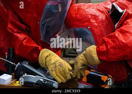 Vigili del fuoco con installazioni di corpi marini Pacific Fire and Emergency Service gestire sostanze chimiche pericolose simulate durante un esercizio di formazione sui materiali pericolosi a Camp Hansen, Okinawa, Giappone, 27 giugno 2022. La formazione HAZMAT ha incluso più vittime simulate in un ambiente pericoloso, neutralizzando al contempo l'area contaminata. MCIPAC F&ES è un reparto antincendio regionale che gestisce otto stazioni antincendio in tutto il Giappone e fornisce servizi alle installazioni, tra cui antincendio, soccorso tecnico, materiali pericolosi, pronto soccorso, protezione antincendio e prevenzione. Foto Stock